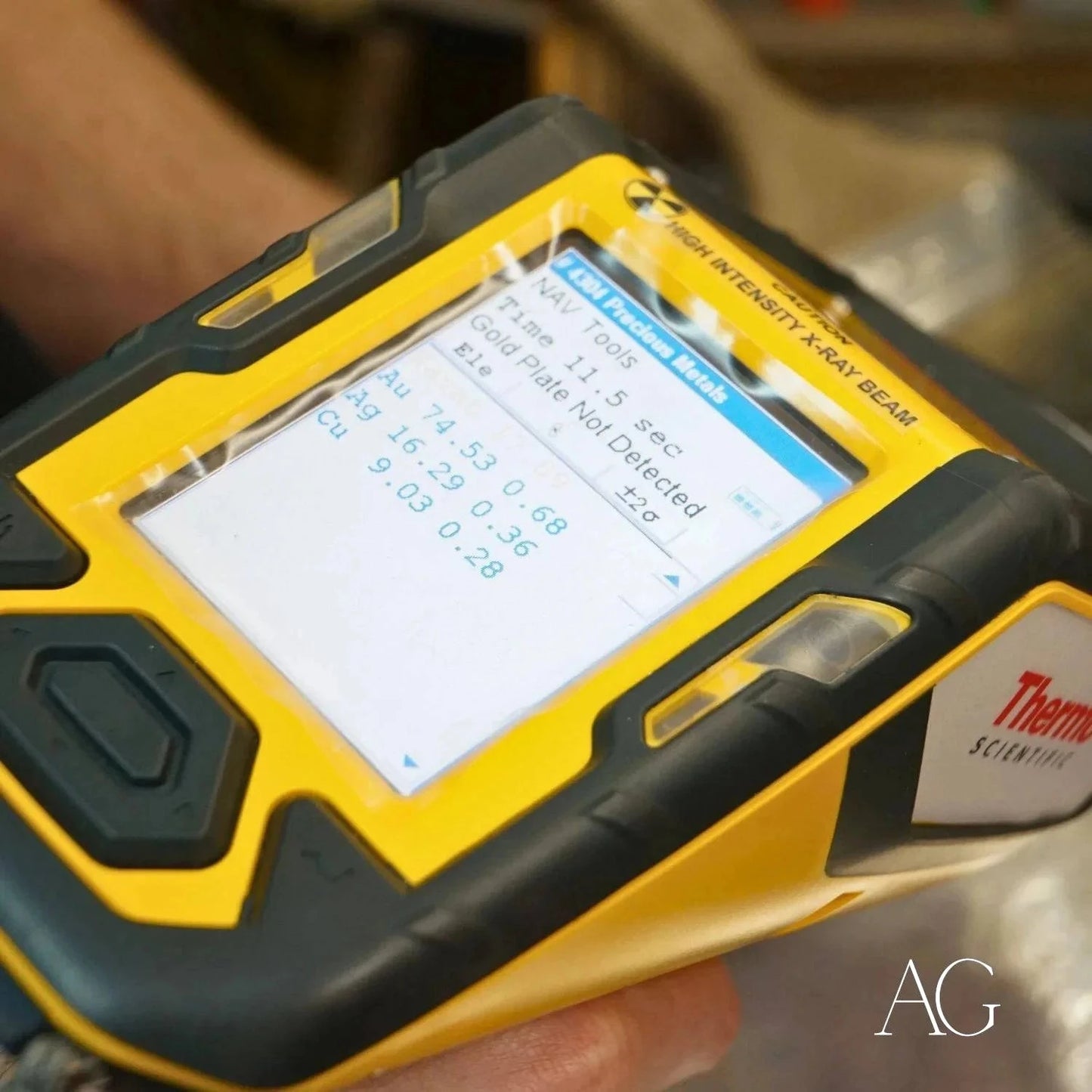 Rugged yellow handheld device showing numerical data for Art Gold jewelry repair