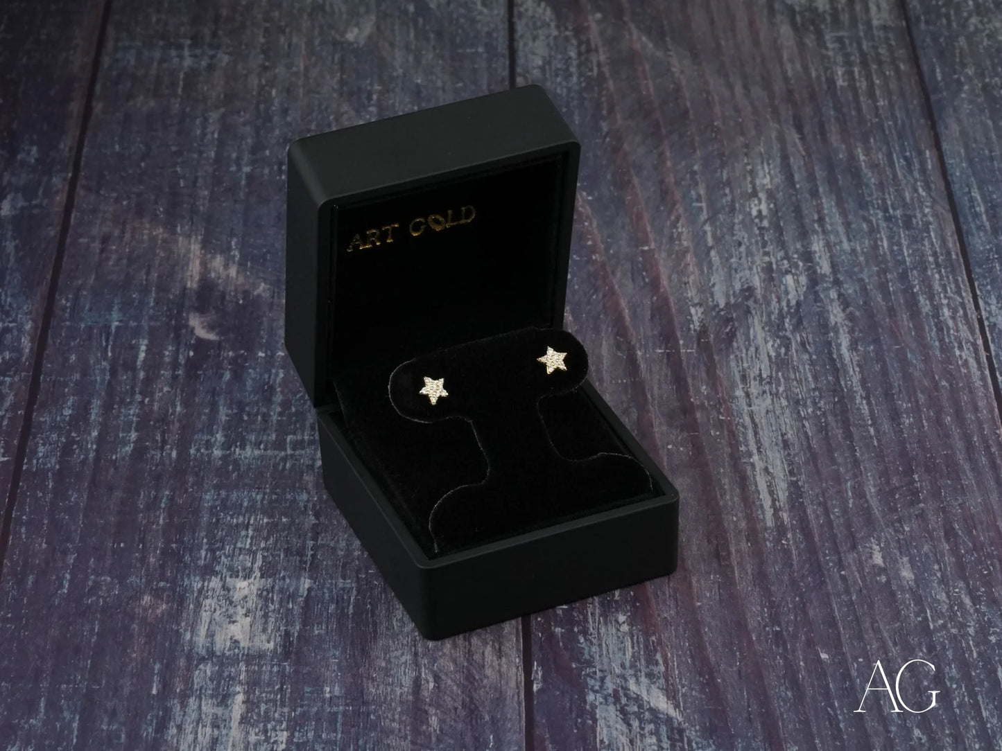 Star earrings displayed in a black jewelry box, featuring art gold jewelry design