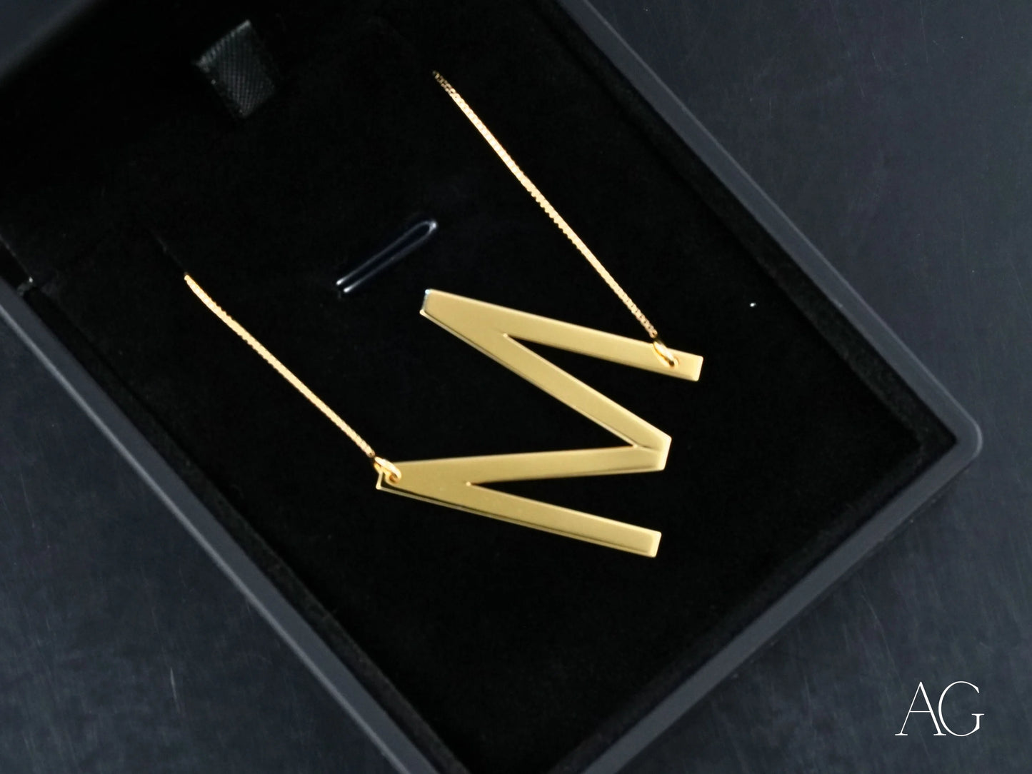 Gold letter M earrings shown with personalized initial letter pendant necklace in box chain