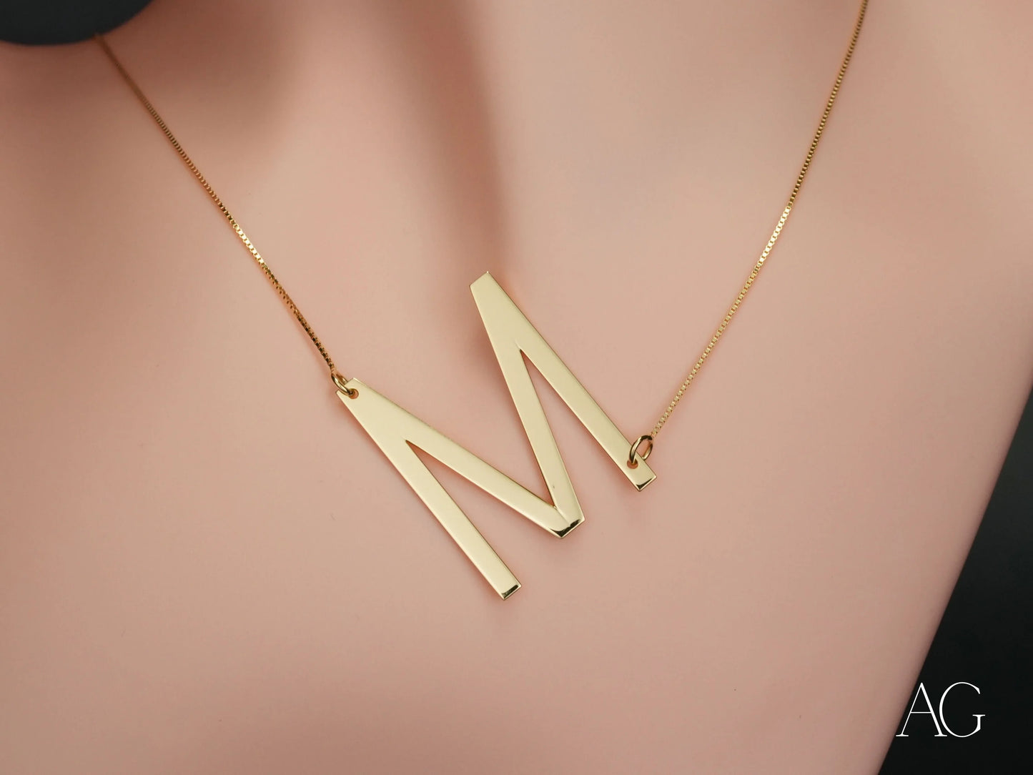 Gold letter M necklace featuring personalized initial letter pendant on box chain