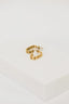 a pair of gold earrings sitting on top of a white box
