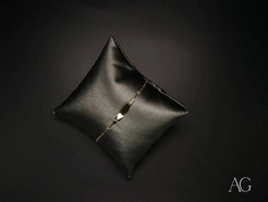 Black leather cushion with diamond tear showcasing 18k gold kid’s ID bracelet with spring ring lock