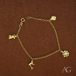 18k gold charm bracelet for kids with four dangling charms showcasing elegance and style