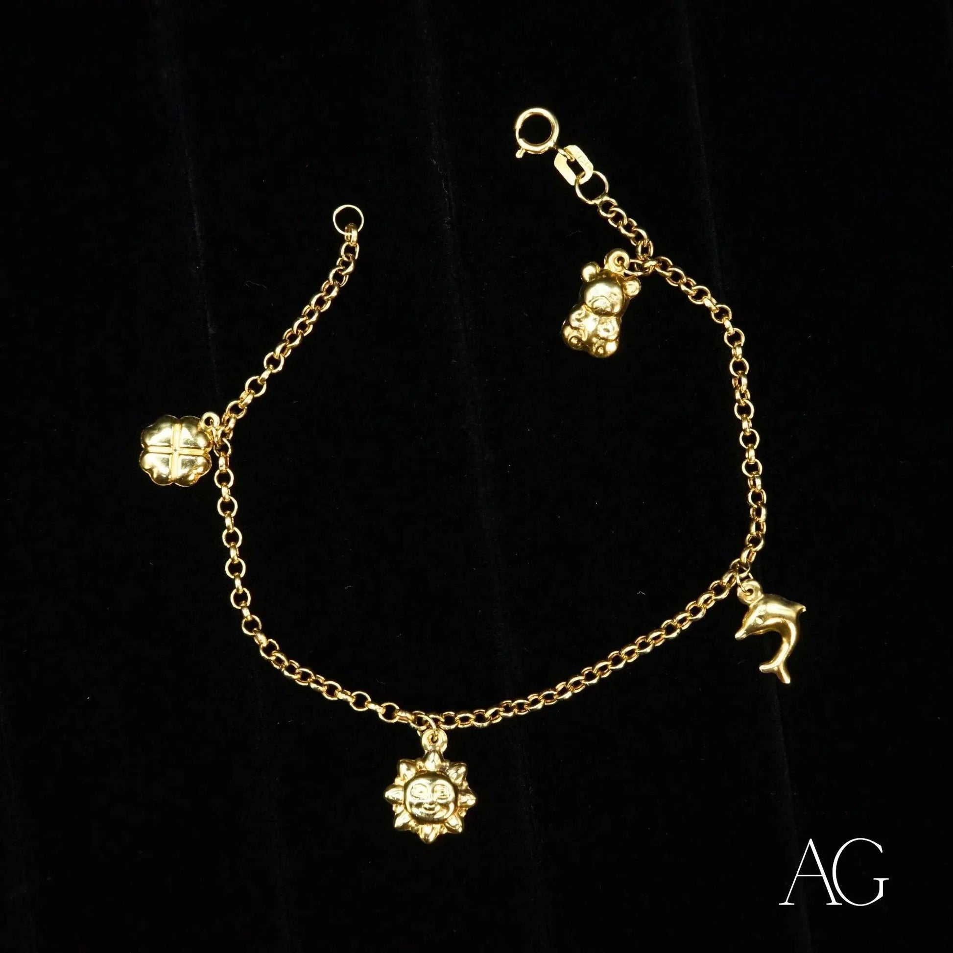 18k gold charm bracelet for kids featuring four dangling charms in elegant design