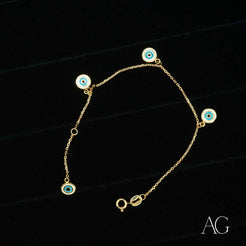 18k gold evil eye bracelet for kids featuring a gold chain with light blue charms