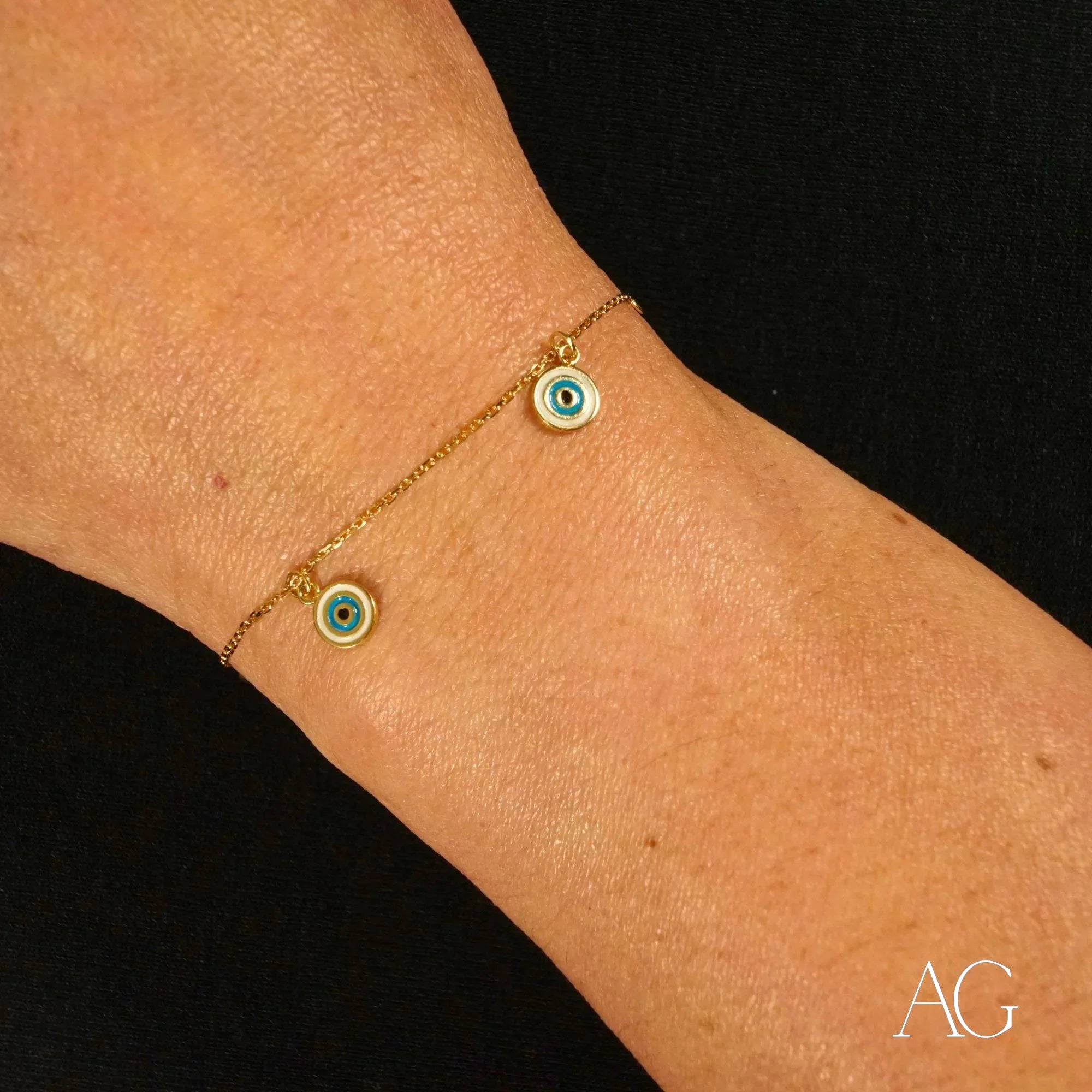 Gold bracelet featuring two small evil eye charms in 18k gold design for kids