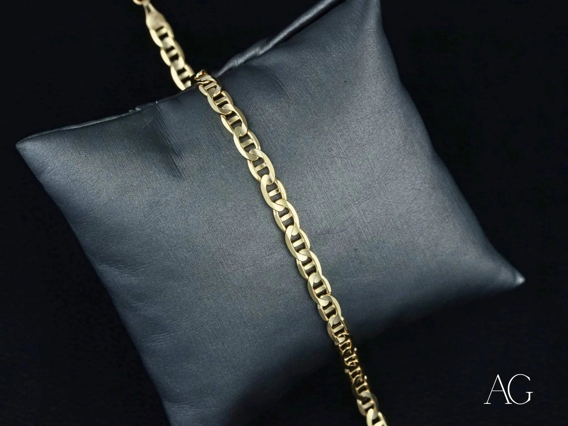 18k Solid Gold bracelet with navy link pattern on a dark cushion background