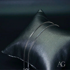 Black leather pillow with decorative metal zippers for showcasing 18k white gold anklet