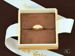 Gold ring with heart design in a brown box, featuring 18k yellow gold elegance