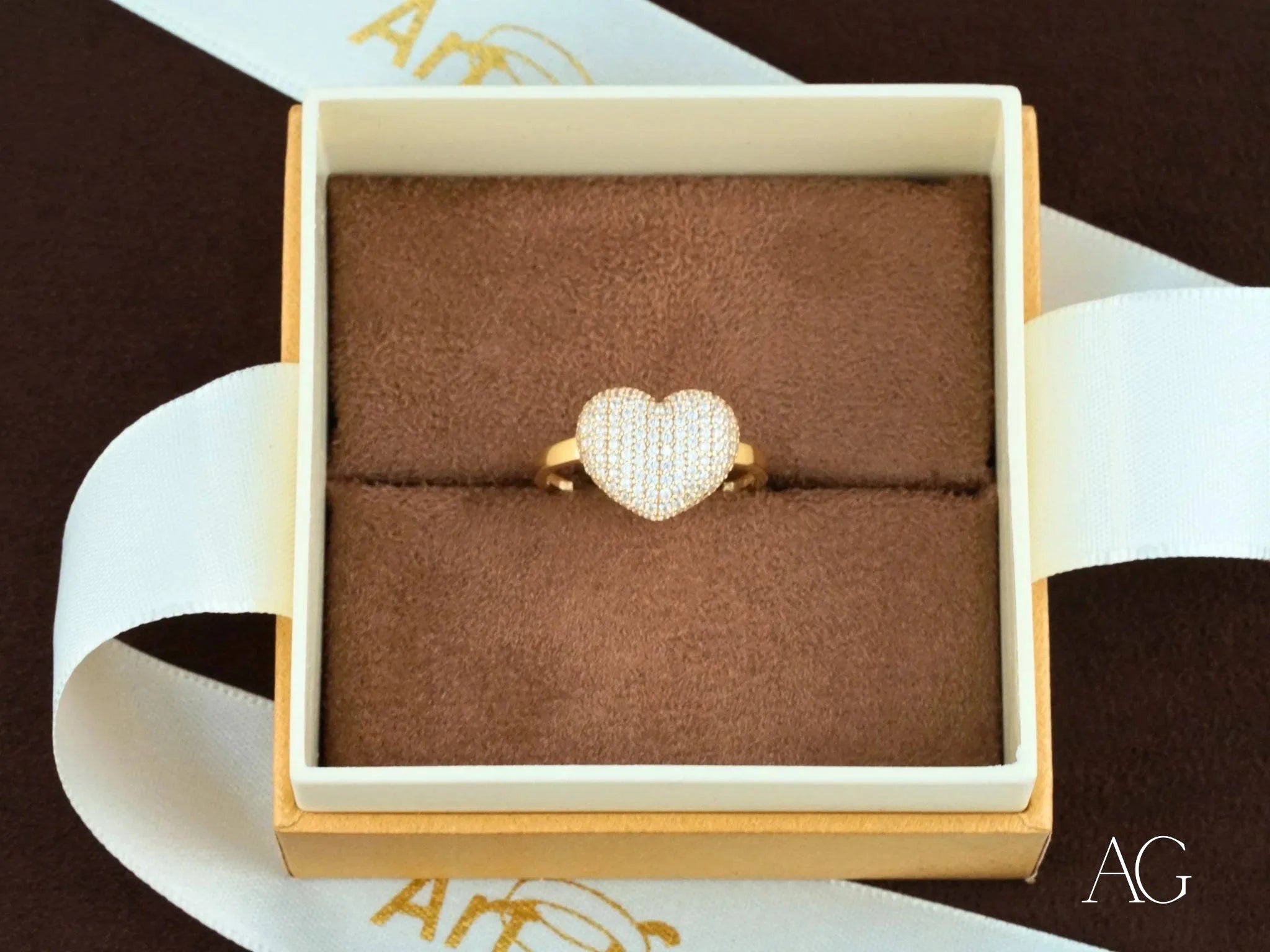 Heart-shaped diamond ring in a jewelry box, showcasing 18k yellow gold elegance