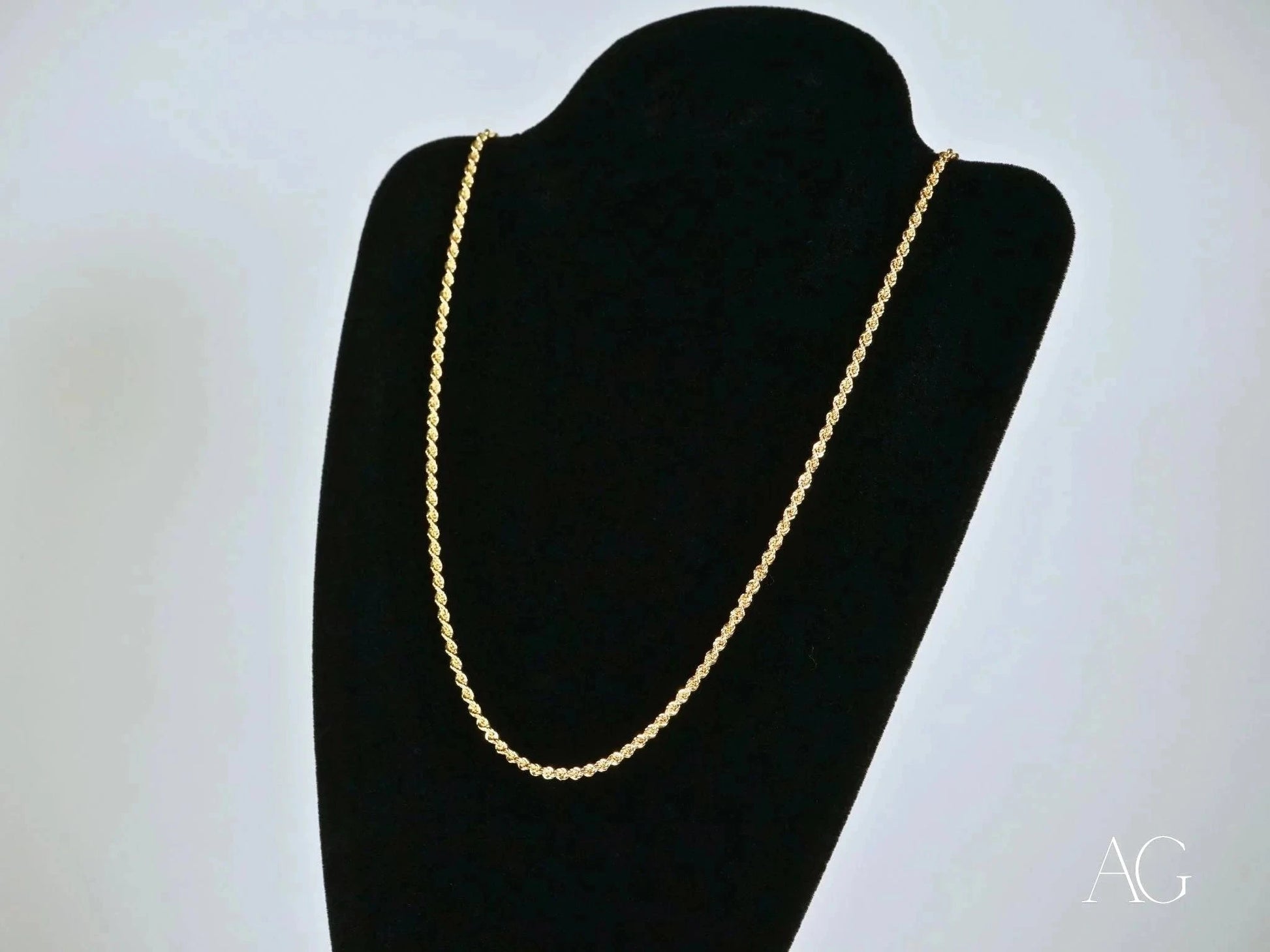 Elegant 14k gold rope chain necklace with secure barrel lock on a black jewelry bust