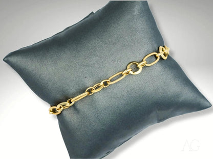 Elegant 18k gold bracelet on dark gray cushion showcasing art gold jewelry craftsmanship