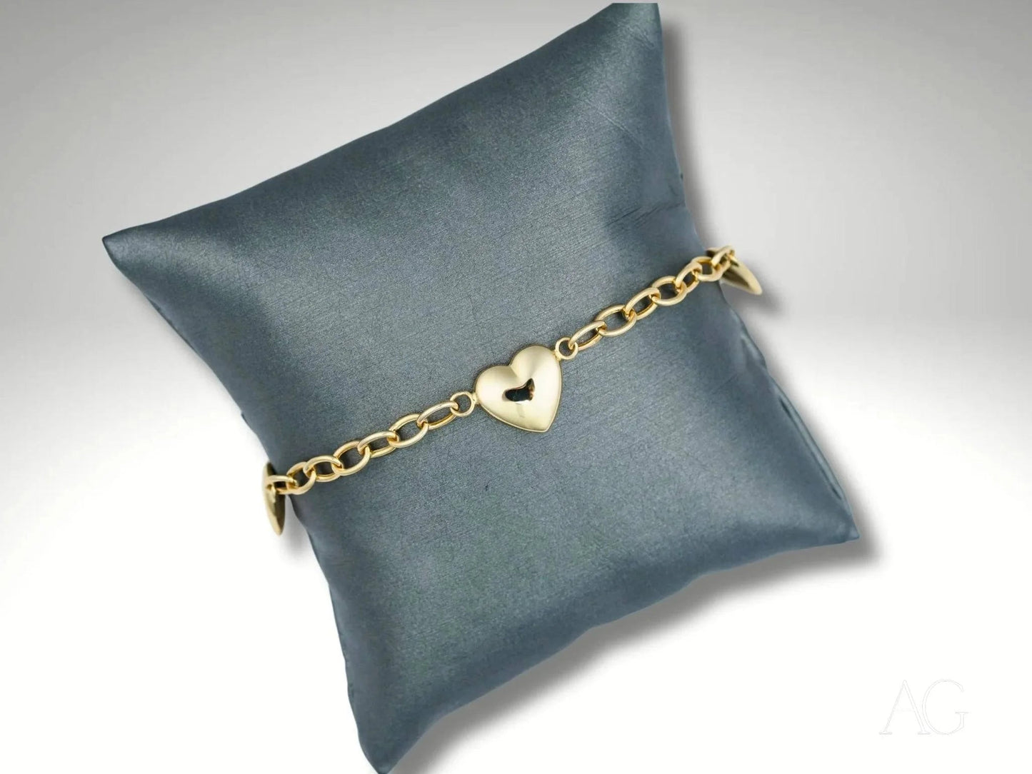 Elegant 18k gold bracelet with heart motifs and a gold chain charm