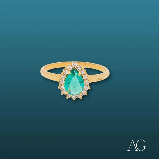 Elegant 18k gold ring with pear-shaped emerald and diamond accents