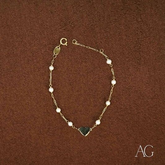 Elegant 18k gold heart and pearl bracelet featuring a delicate gold heart charm