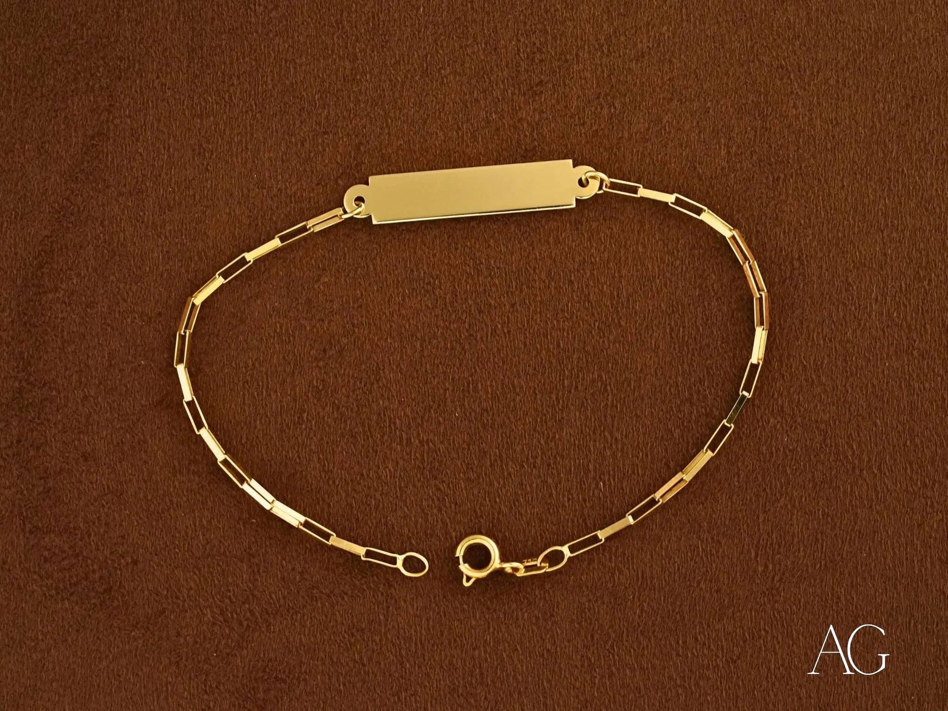 Gold bracelet with rectangular nameplate and delicate chain links in solid 18k gold