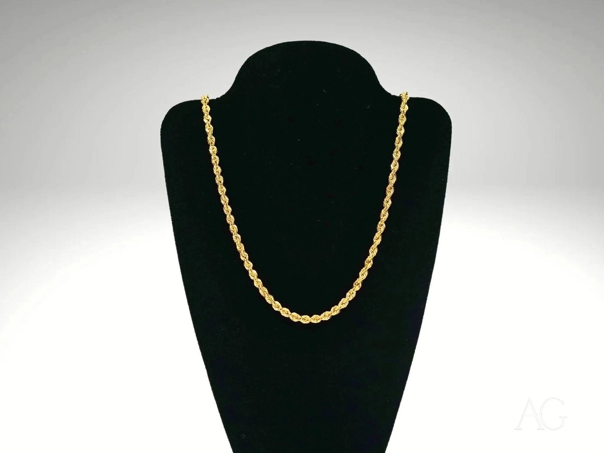Elegant 18k gold rope chain necklace on a black velvet jewelry stand