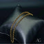 18k gold anklet elegantly draped on dark gray cushion showcasing timeless elegance