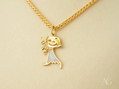 Gold Doll Pendant featuring a stick figure charm in 18k gold with textured dress pattern