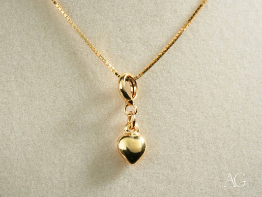 18k gold golden heart pendant elegantly hanging from a delicate chain necklace