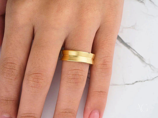 Gold wedding band on a finger showcasing the Comfort Fit design in 14k gold