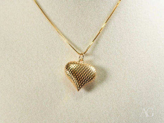 Gold heart-shaped pendant necklace with a textured mesh pattern in 18k gold design