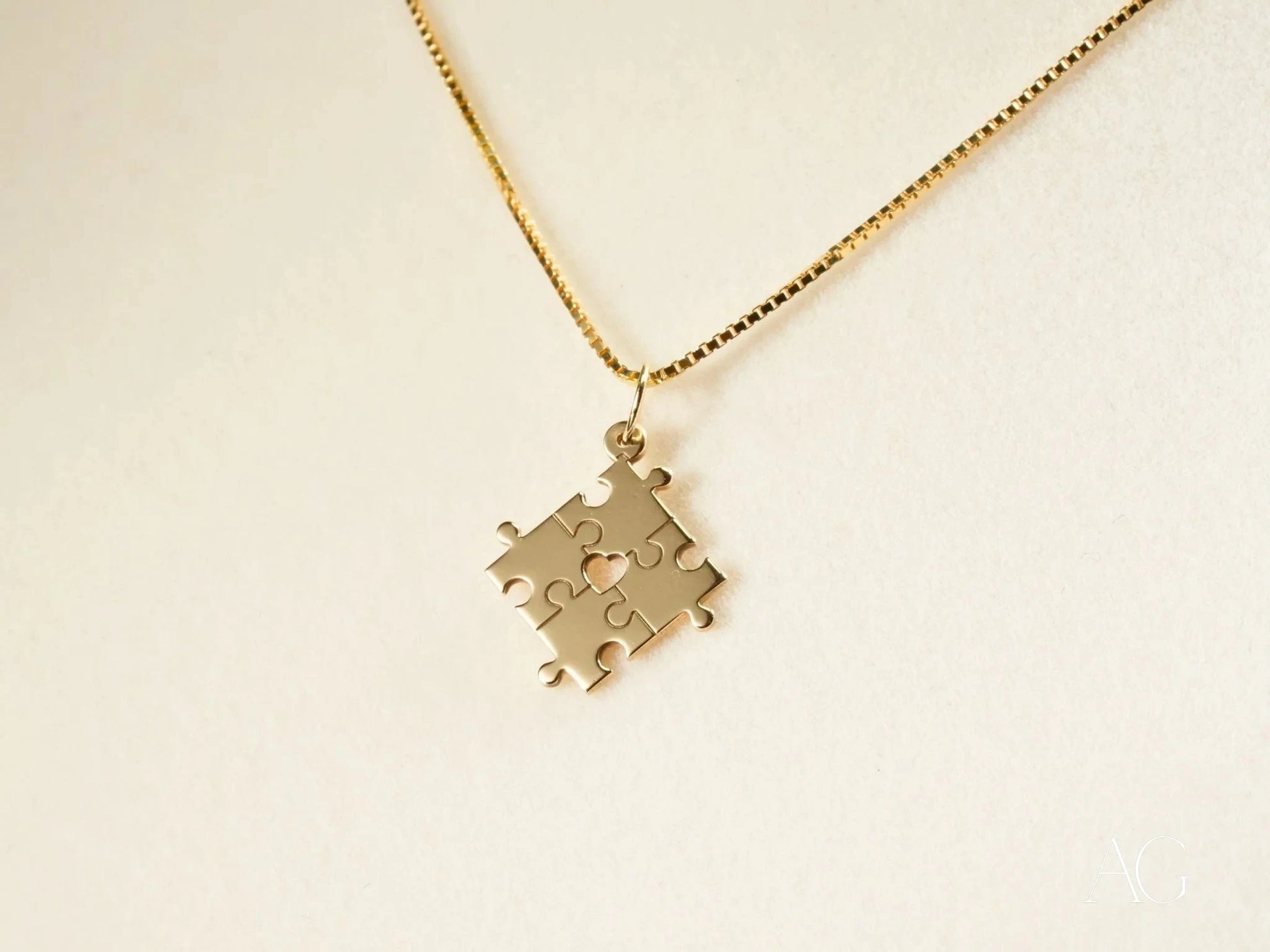 Gold-colored puzzle piece pendant on a delicate chain for Autism Awareness in 18k gold