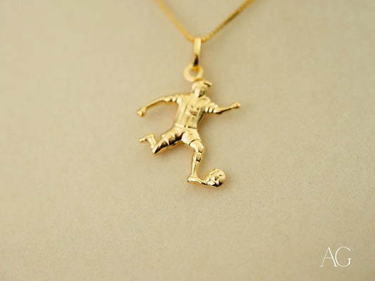 Gold pendant of a soccer player in action, part of the Golden Striker collection