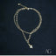 Luxurious 18k double chain anklet with heart charm on dark background.