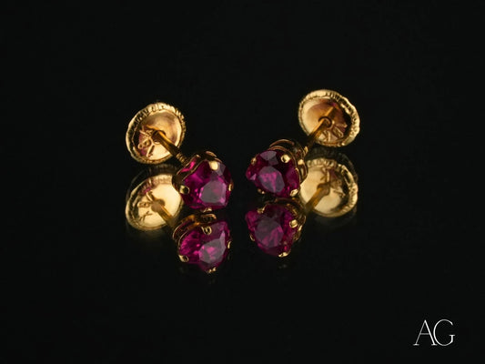 Gold and ruby stud earrings featuring ruby-red cubic zirconia in heart design