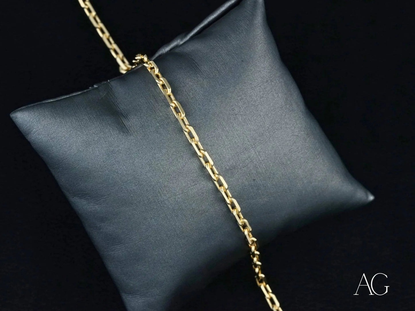 Gold chain necklace on dark gray cushion showcasing 18k solid gold elegance