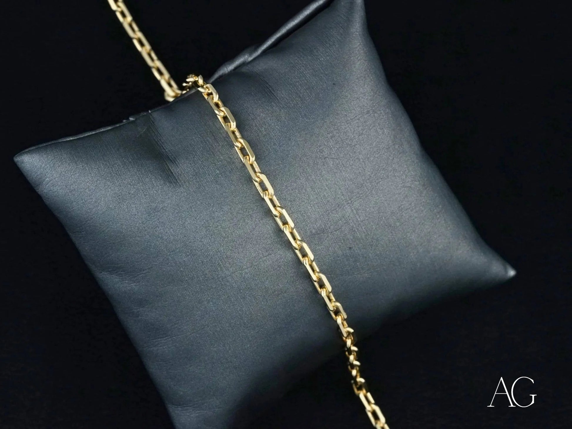 Gold chain necklace on dark gray cushion showcasing 18k solid gold elegance