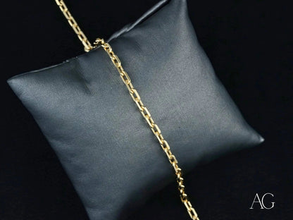 Gold chain necklace on dark gray cushion showcasing 18k solid gold elegance