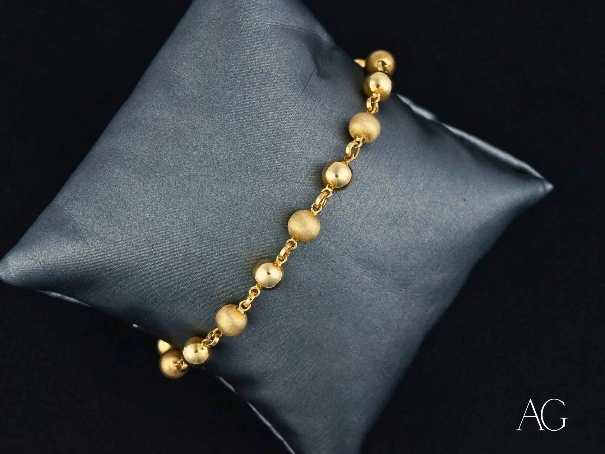 Radiant Elegance 18k solid gold bracelet with spring ring clasp on dark cushion