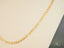 Regal Prestige 18K Yellow Gold Figaro Chain showcasing elegant art gold jewelry design
