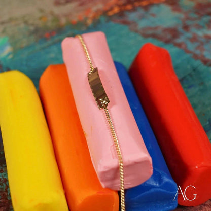 Gold chain bracelet on pink display featuring 18k solid gold ID plate for kids
