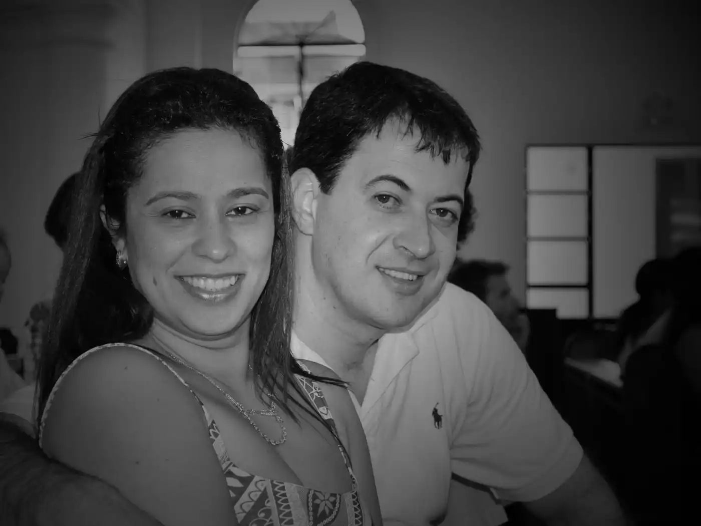 A black and white photograph of a smiling couple sitting together.