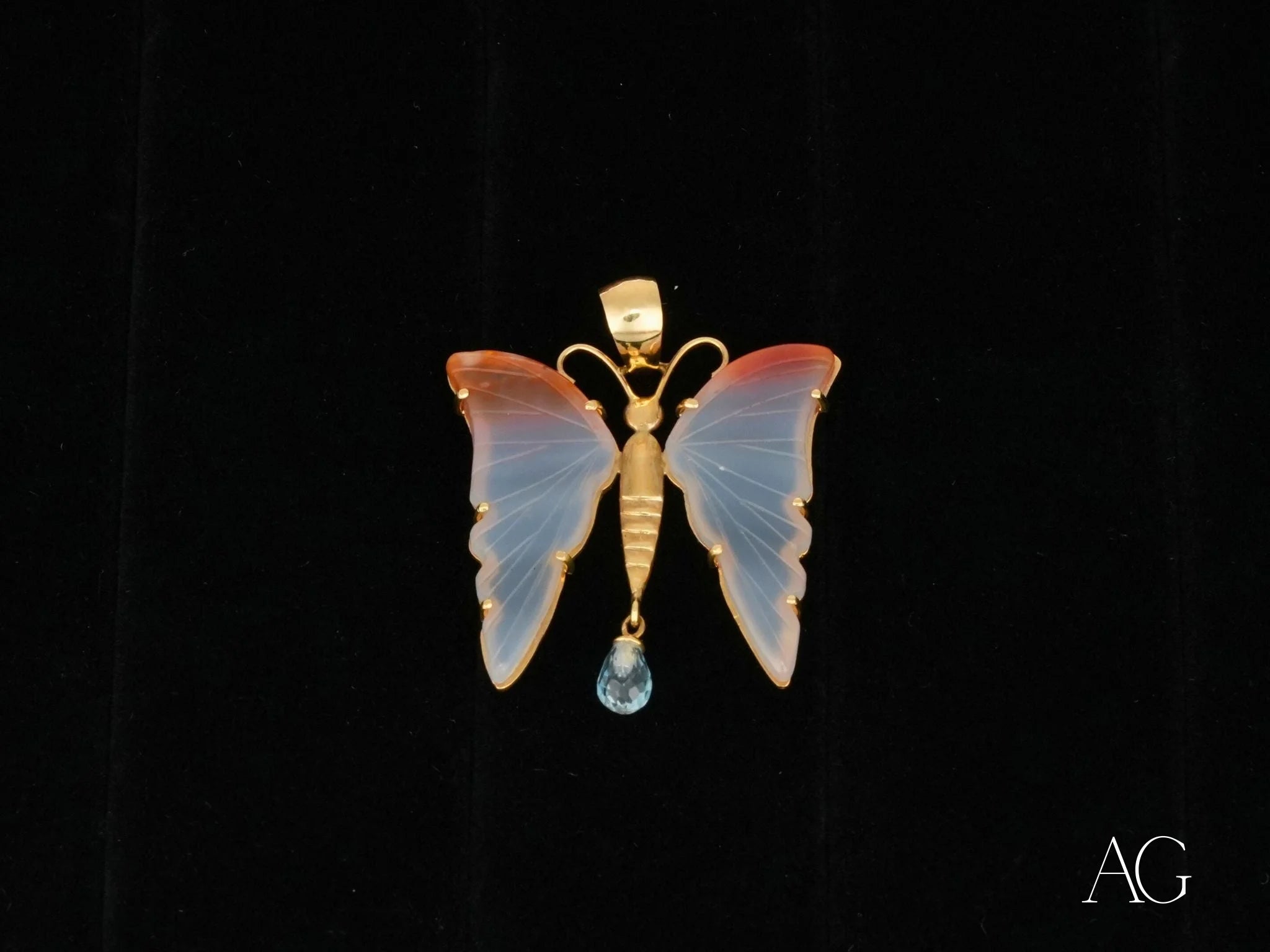 Delicate Butterfly Bliss pendant in 18k gold with opalescent wings and blue topaz