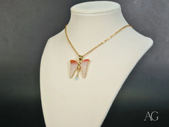 Delicate Butterfly Bliss necklace with pink wings and 18k gold chain, featuring topaz gemstones