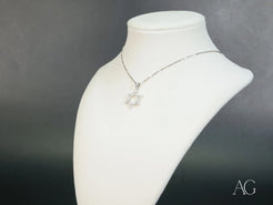 Silver necklace with 18k White Gold CZ pendant on a jewelry bust. Celestial Star of David