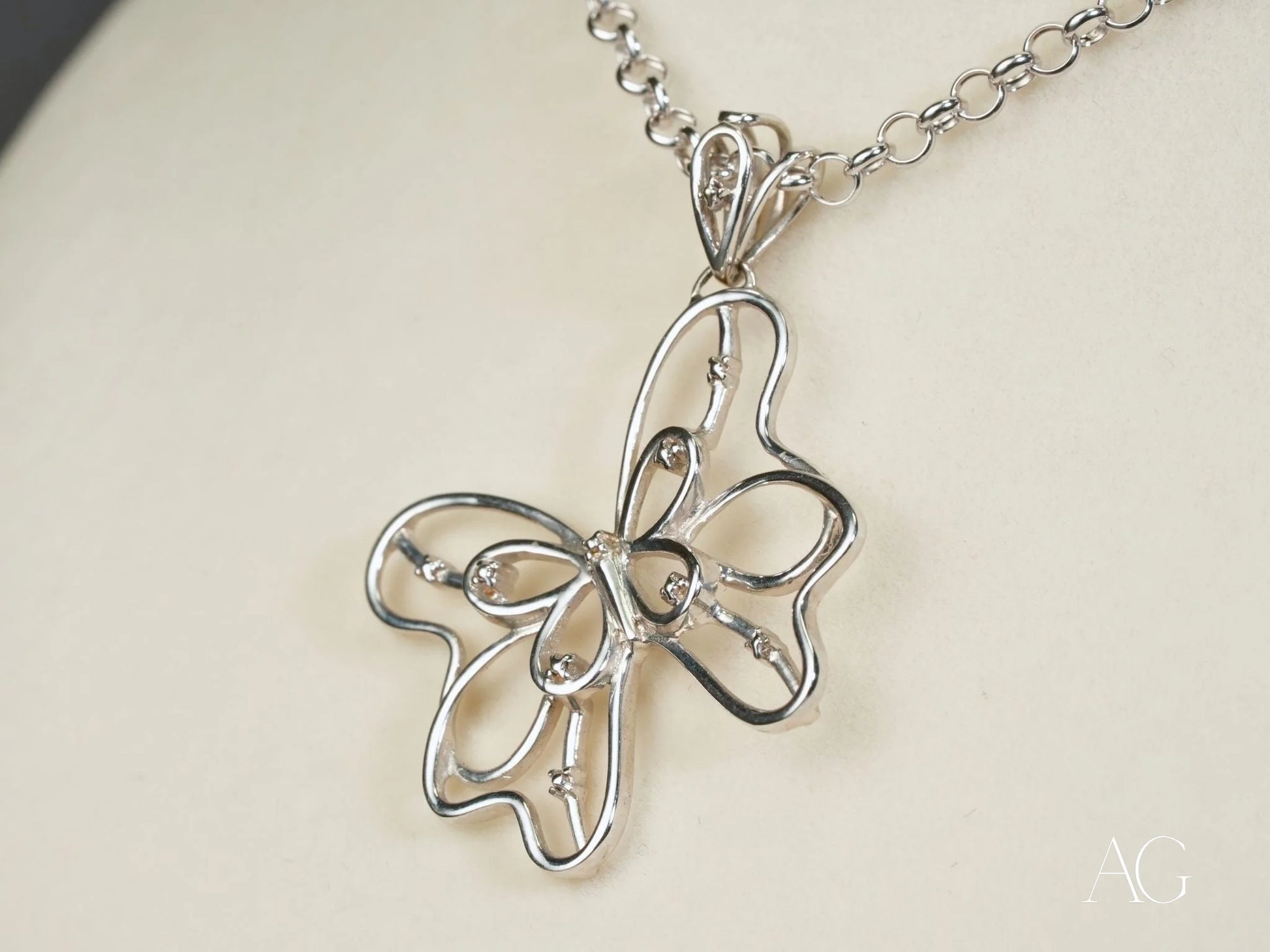 Silver butterfly pendant necklace in elegant open-work design, crafted in 18k white gold