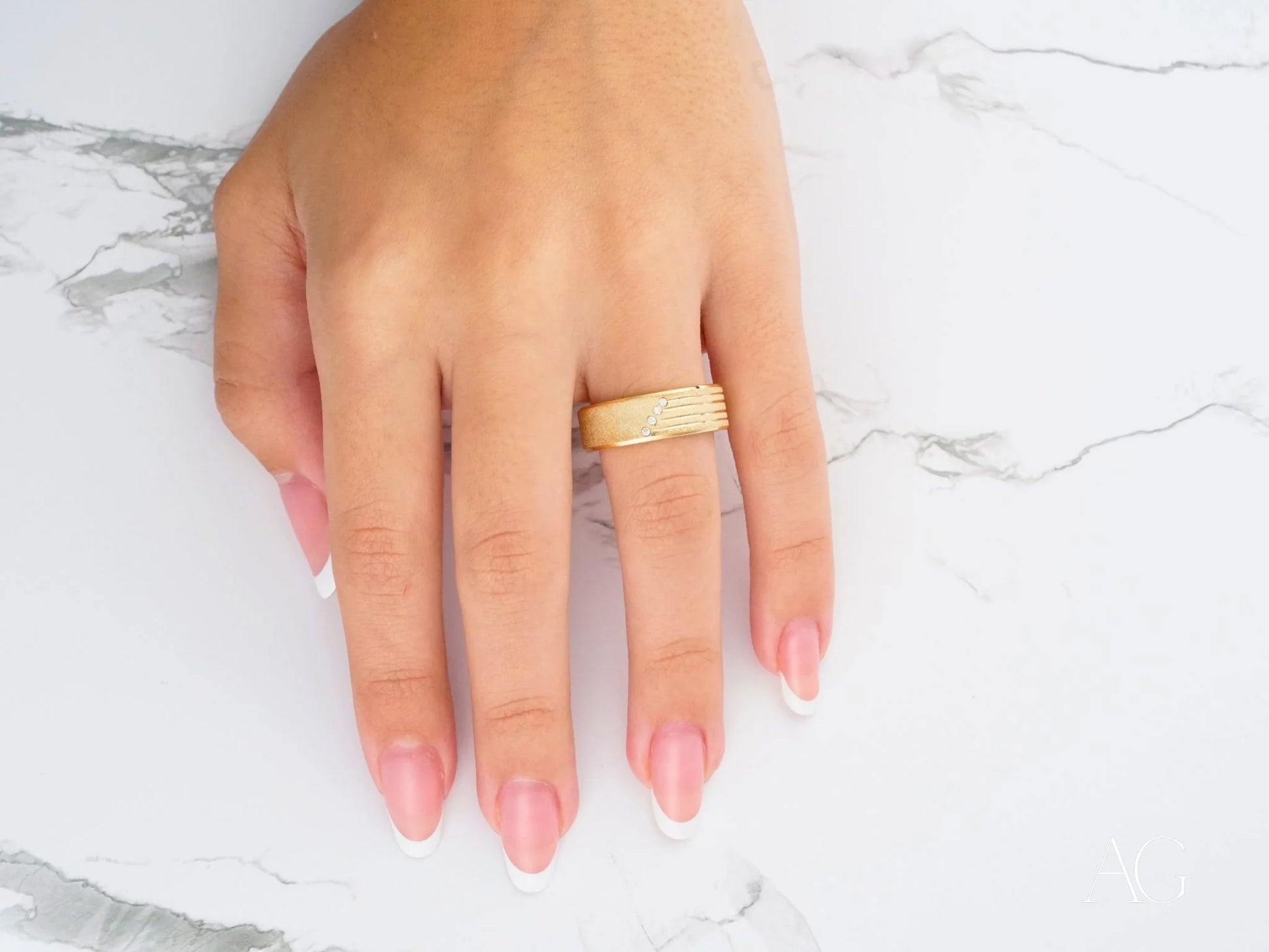 Gold 14k wedding band with pink manicured nails showcasing Celestial Path design