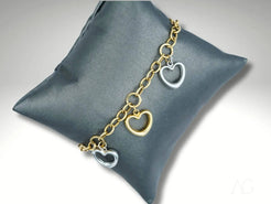 Charm bracelet with heart-shaped pendants in 18K art gold and white gold on gray cushion