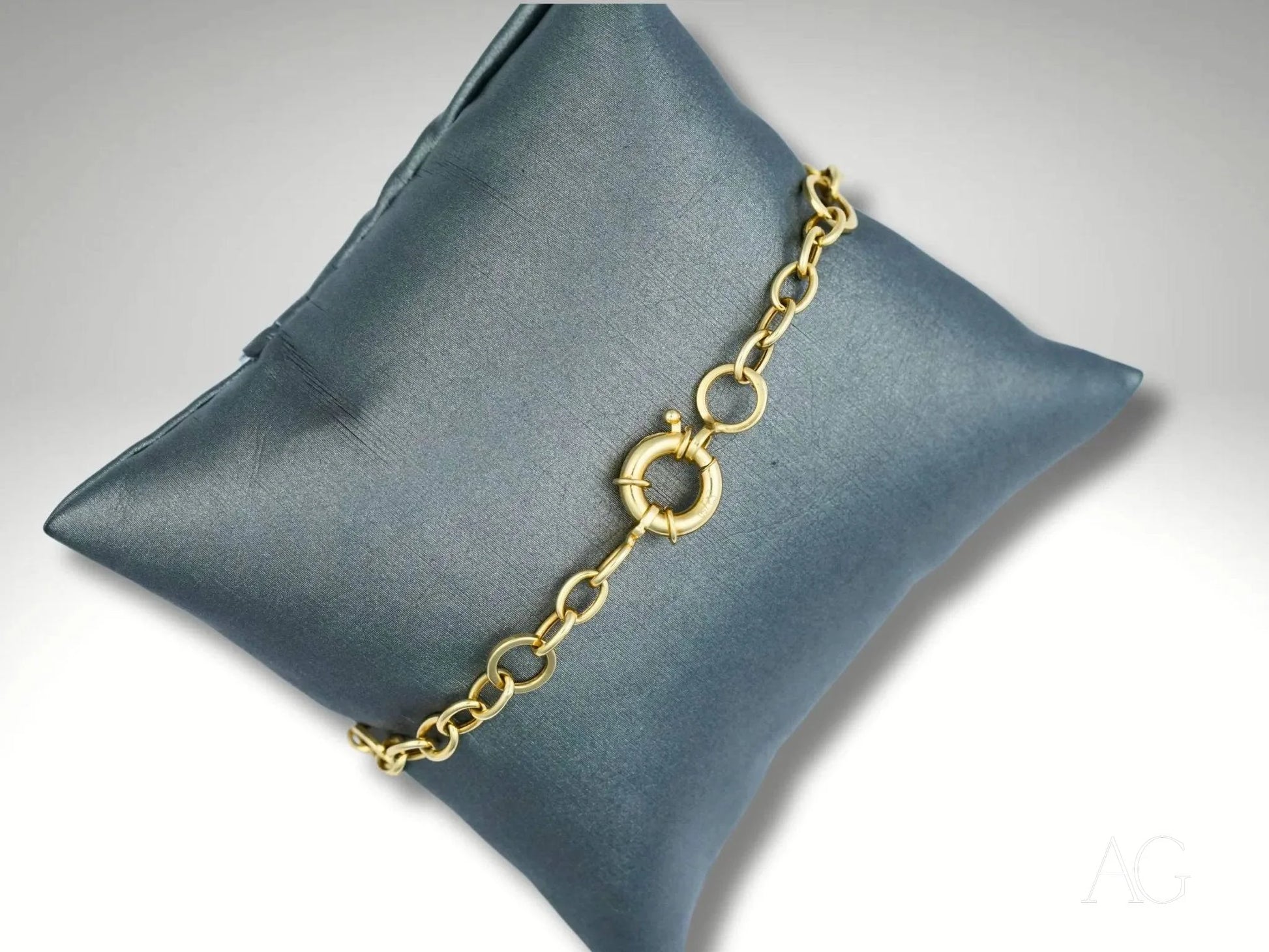 Gold chain bracelet in 18k yellow and white gold on gray cushion art gold jewelry