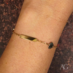 Gold bracelet with heart motif charm, a children’s ID bracelet in yellow gold