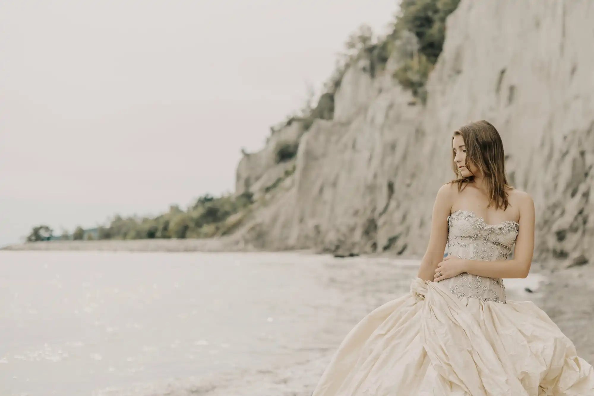 A flowing cream-colored wedding dress with a strapless bodice and ruffled skirt.