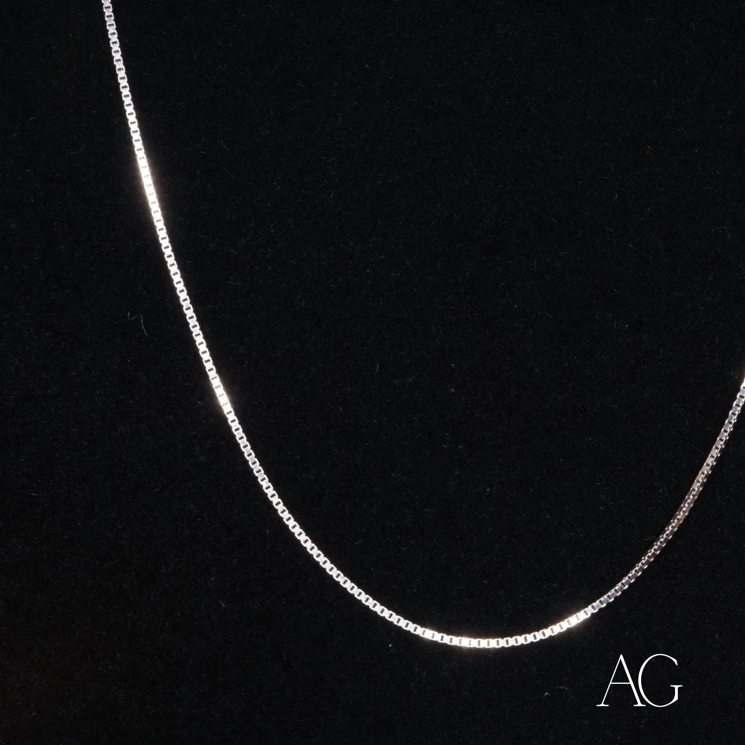 Delicate 18k white gold box chain necklace on a dark background showcasing petite elegance