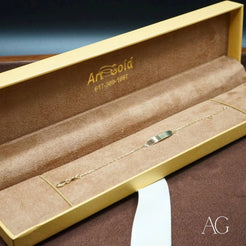 Gold jewelry box with an 18k solid gold kids’ ID bracelet showcasing delicate elegance