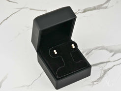 Pearl stud earrings in a black box showcasing elegant art gold jewelry design