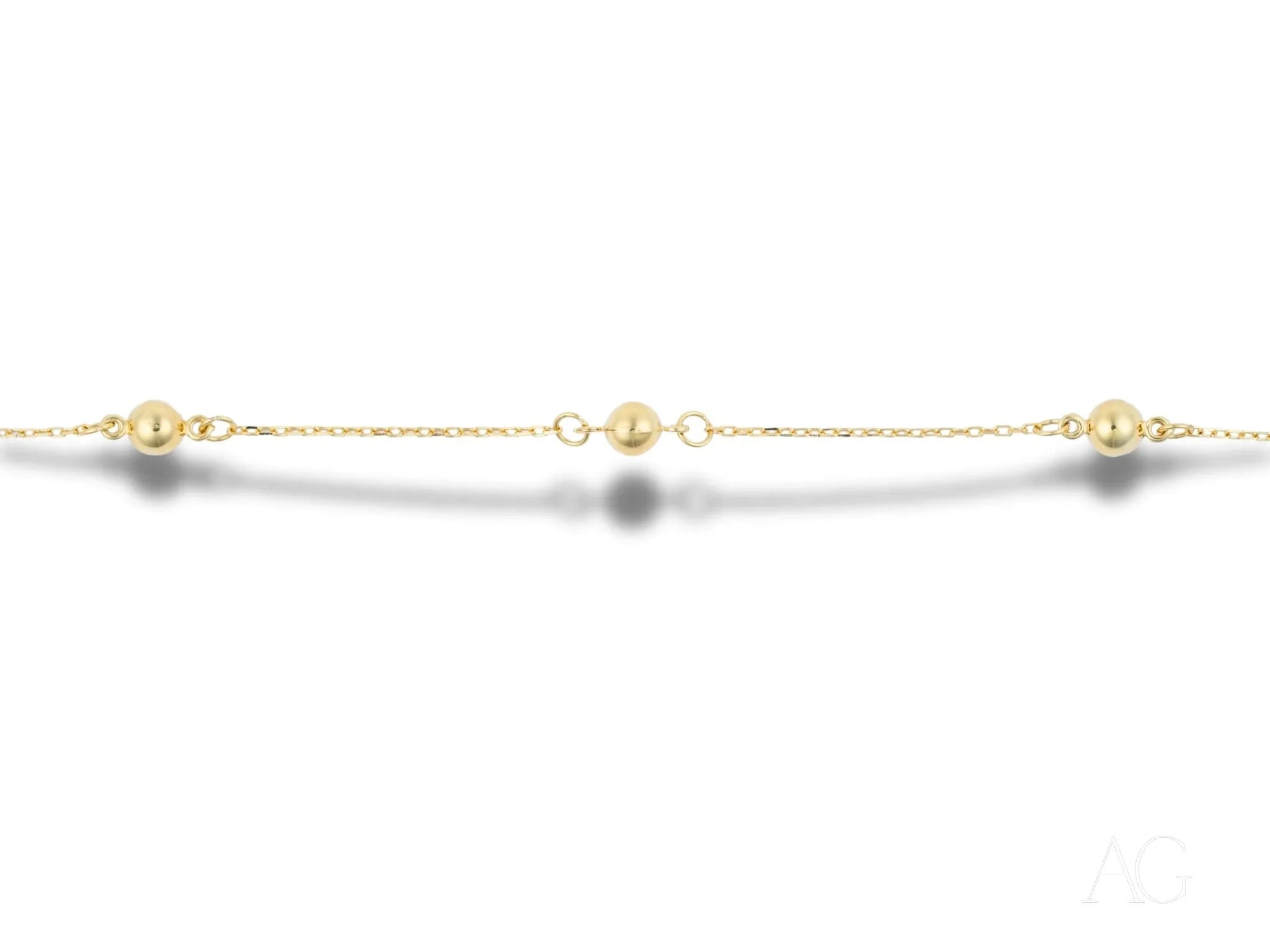 Delicate 18k gold bracelet featuring polished gold spheres and small spaced beads